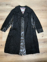 Load image into Gallery viewer, Kingspier Vintage - Salon Fernande Furs black persian wool coat with black leather trim details, four button closures down the front pockets and striking blue and bronze paisley lining with inside pockets. Made in Montreal.
