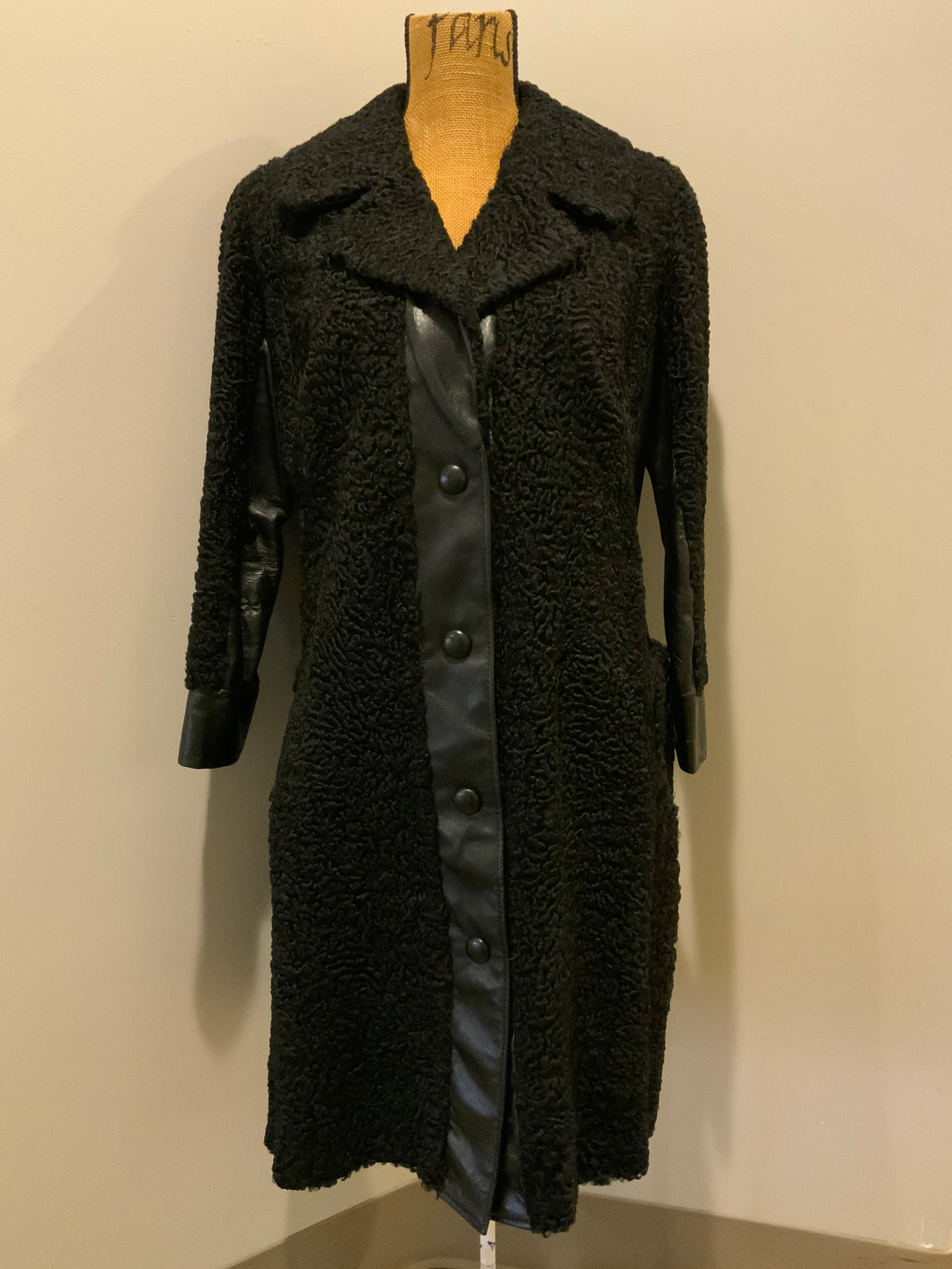 Kingspier Vintage - Salon Fernande Furs black persian wool coat with black leather trim details, four button closures down the front pockets and striking blue and bronze paisley lining with inside pockets. Made in Montreal.