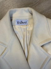 Load image into Gallery viewer, Kingspier Vintage - Raffinati 1980’s double breasted wool blend coat in cream. This coat features unique gold buttons in front, front pockets and a belt in the back. Fits a size 8.
