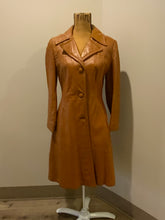Load image into Gallery viewer, Kingspier Vintage - Form fitting 1970’s full length caramel brown leather coat with buttons down the front and a fun woven motif lining.
