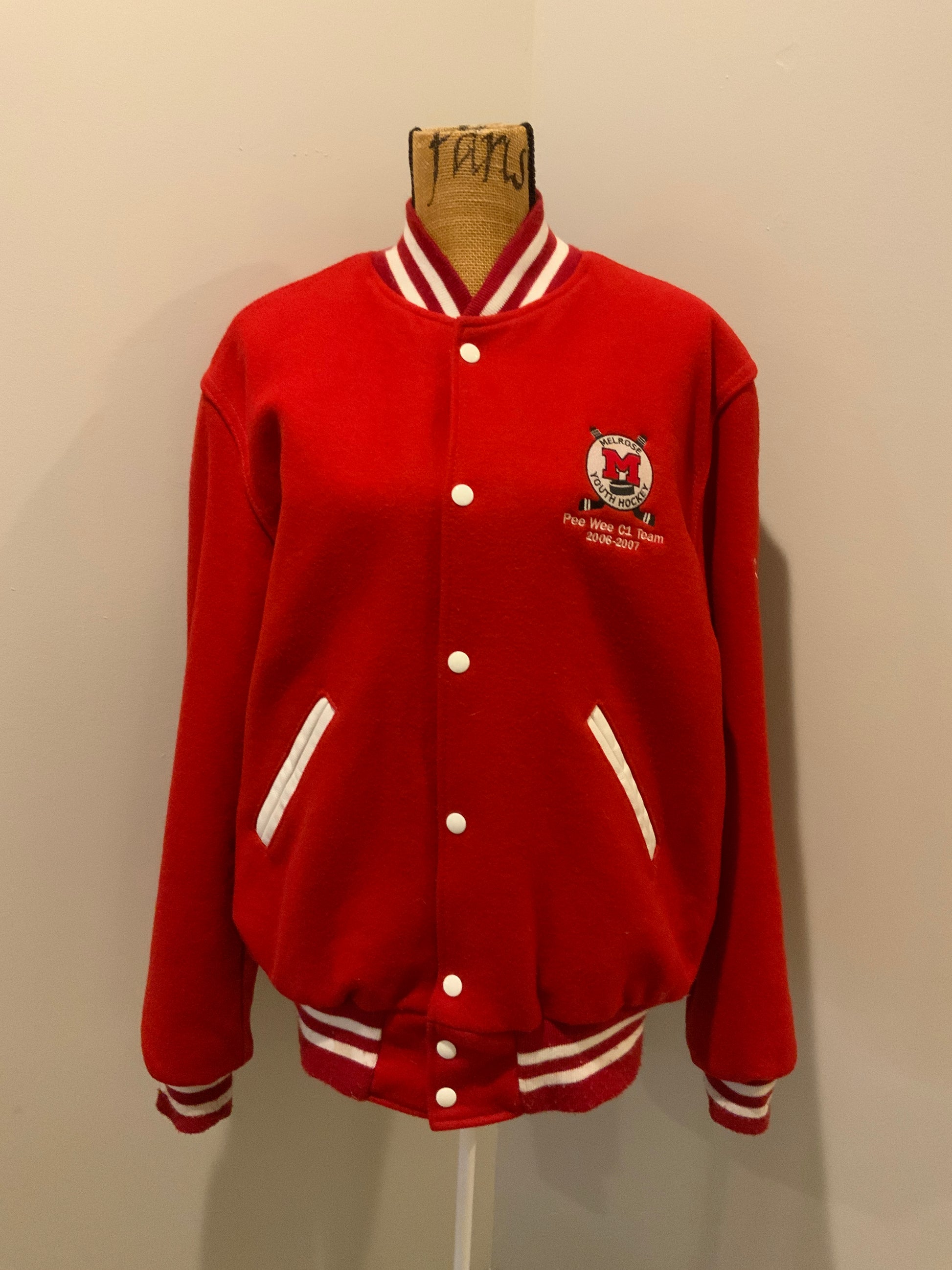 Kingspier Vintage - Melrose Youth Hockey letterman’s jacket in red with white accents, embroidered emblem on the front and lettering on the back with monogram on shoulder “Kevin”. Snap closures, slash pockets. Made in the USA. Size M.