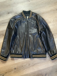 Kingspier Vintage - Retreat circa early 2000’s black leather bomber jacket with light brown stripe detailing, front zipper, slash front pockets and two inside pockets. Size 44.