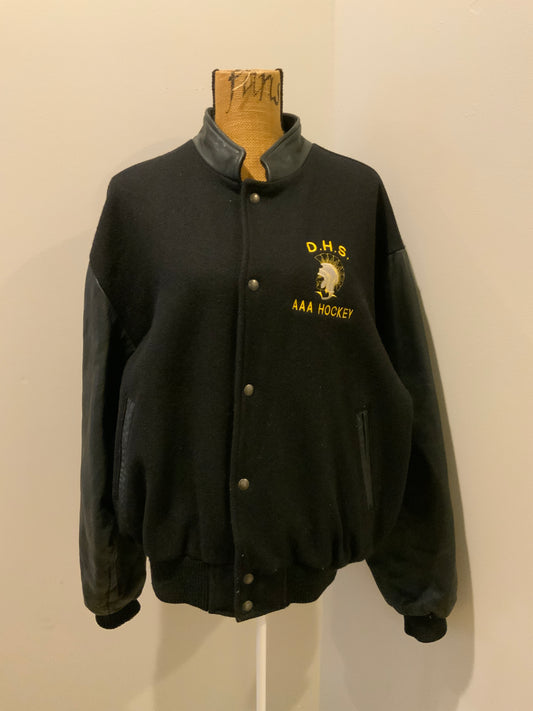 Kingspier Vintage - Dartmouth High School AAA Hockey letterman’s jacket in black with snap closures, slash pockets, quilted lining and embroidered team emblem. Made in Canada. Size XL.