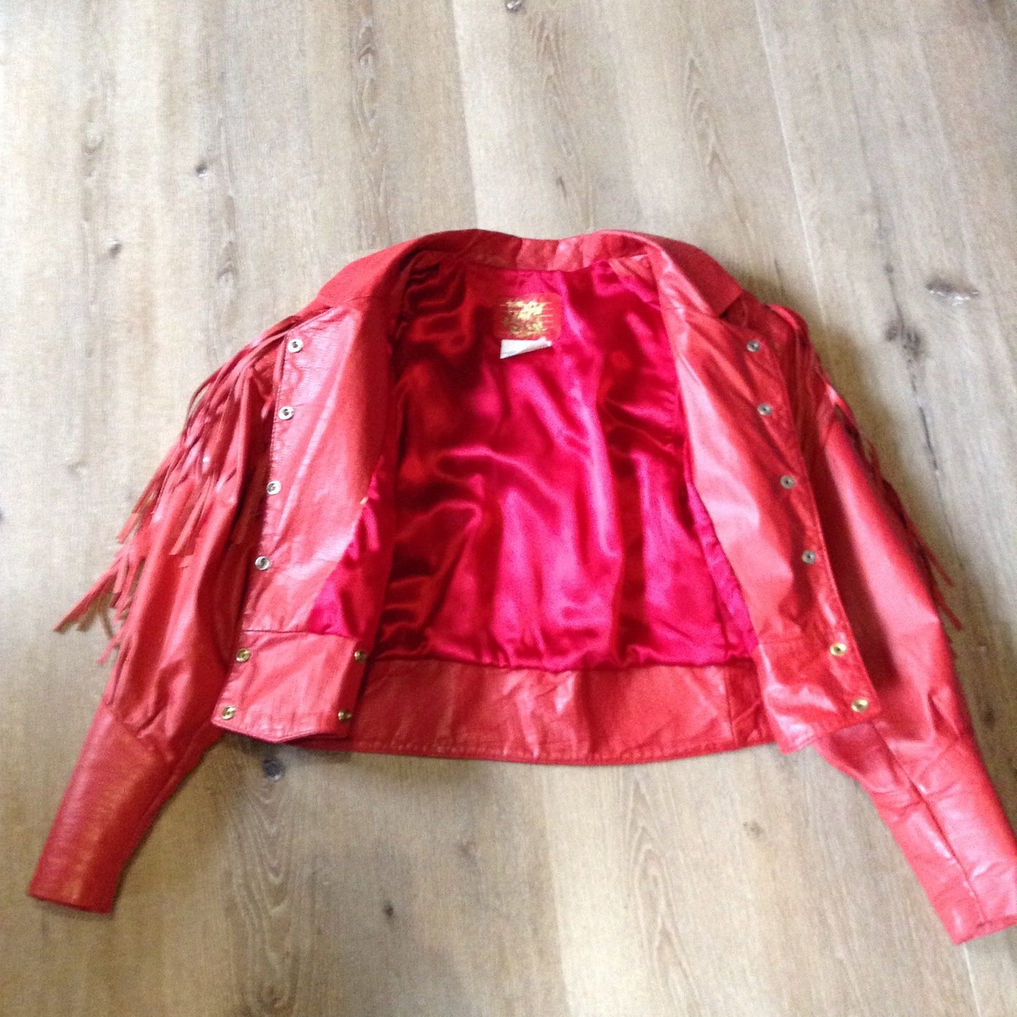 Kingspier Vintage - The Leather Ranch red fringe leather jacket with snap closures and red satin lining . Made in Canada, size XL.
