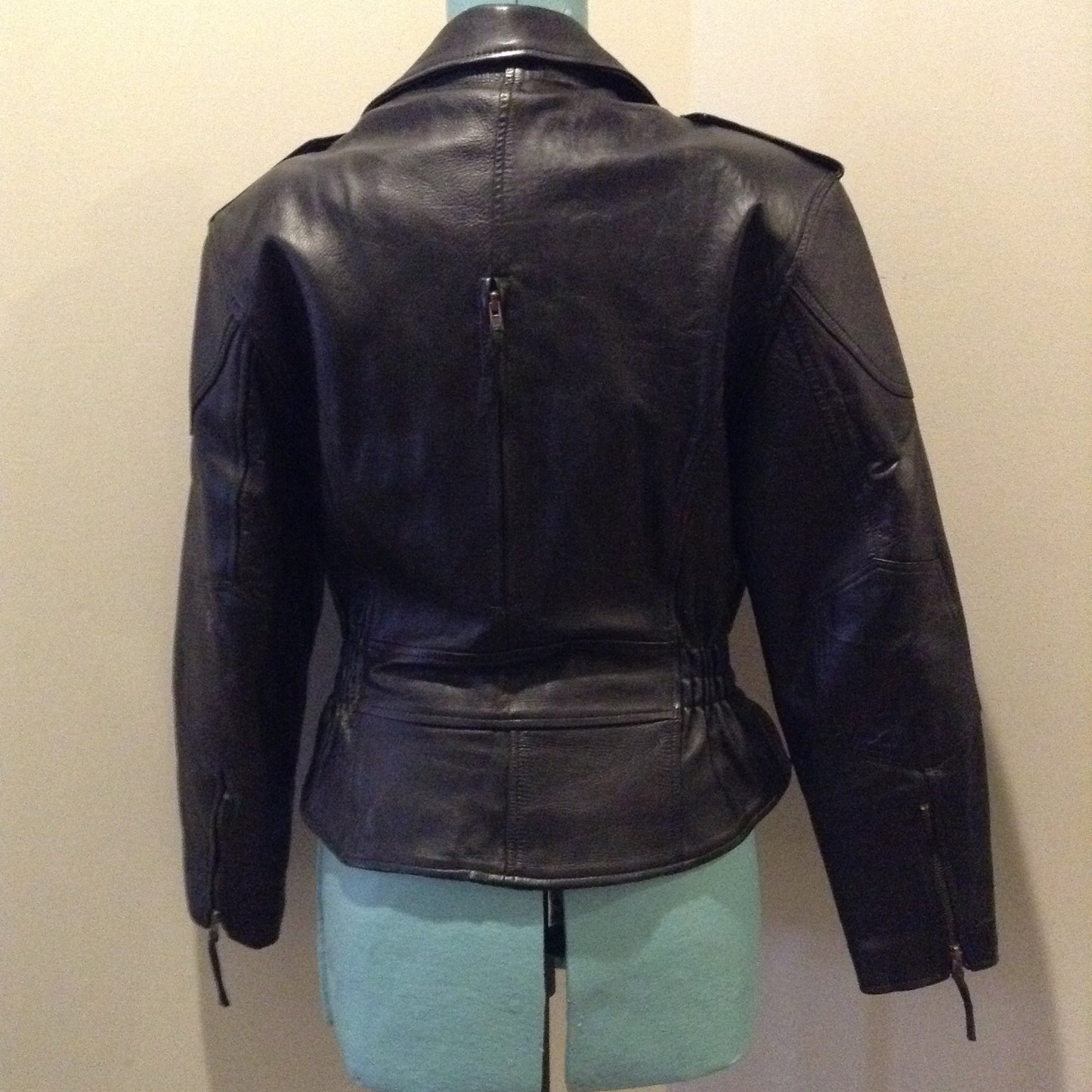 Kingspier Vintage -Vintage black leather moto jacket with brass hardware and zipper closure, belt details and a zipper reveals a vent in the back . Size large.
