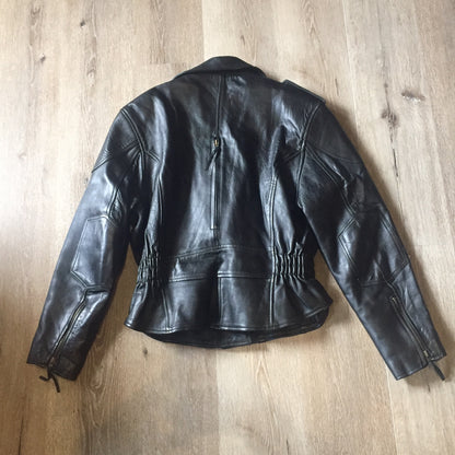 Kingspier Vintage -Vintage black leather moto jacket with brass hardware and zipper closure, belt details and a zipper reveals a vent in the back . Size large.
