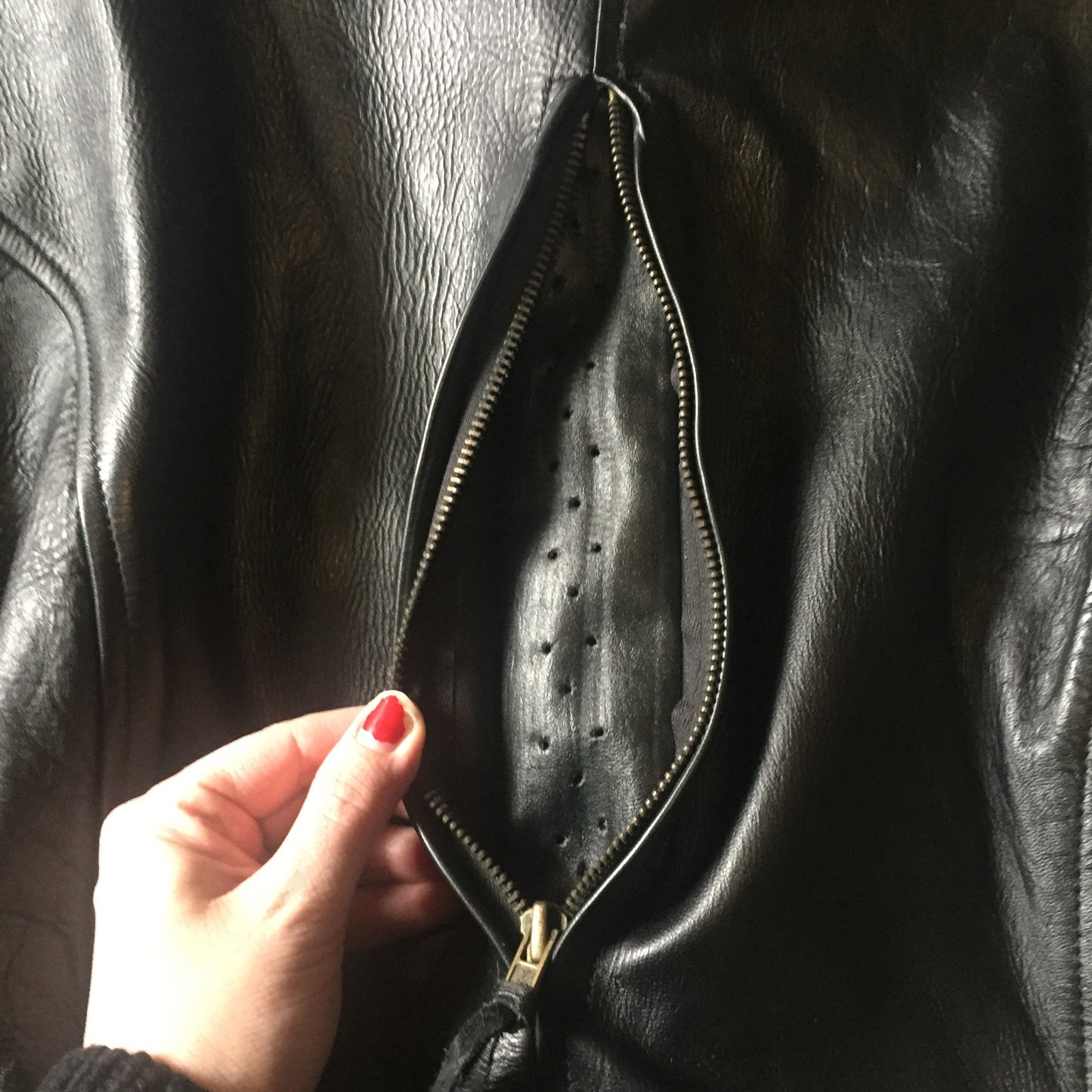 Kingspier Vintage -Vintage black leather moto jacket with brass hardware and zipper closure, belt details and a zipper reveals a vent in the back . Size large.
