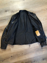 Load image into Gallery viewer, Kingspier Vintage - Taurus by Drospo black leather moto jacket with stretch detailing on the sides and a belt at the waist, zipper down the front, standing collar with Velcro strap, slash pockets and a quilted lining with inside pocket. Size 38. Made in Canada. 
