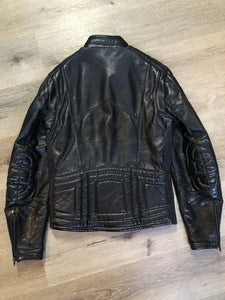 Kingspier Vintage - Taurus by Drospo black leather moto jacket with stretch detailing on the sides and a belt at the waist, zipper down the front, standing collar with Velcro strap, slash pockets and a quilted lining with inside pocket. Size 38. Made in Canada. 