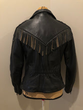 Load image into Gallery viewer, Kingspier Vintage - Hein Gericks black leather motorcycle jacket with fringe detail, zipper, vertical zip pockets lace-up shoulder detail, a quilted lining with inside pocket. Fits Small. 
