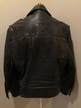 Load image into Gallery viewer, Kingspier Vintage - Action black leather motorcycle jacket with fringe detail and belt at waist. Zipper closure and zip slash pockets, quilted lining with inside pocket. Made in Canada. Size 40. 
