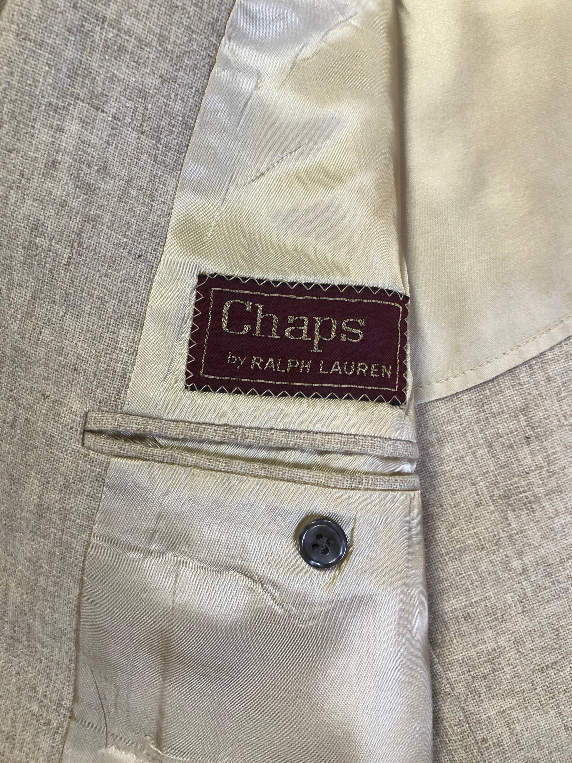 Kingspier Vintage - Chaps by Ralph Lauren light beige two piece suit  at Martini Carl Boston. Jacket is a three button notch lapel with three flap pockets and a breast pocket. The pants are flat front with two slash pockets, a tiny flap pocket in the front and two back pockets.