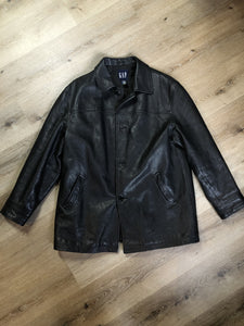 Kingspier Vintage - Gap black leather jacket with button closures, slash pockets, inside pocket and quilted lining. Size large. 