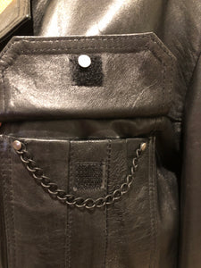 Kingspier Vintage - Kashmir Garments black leather jacket features two flap pockets on the chest with hidden chain detail underneath and skull button closures. Size medium.