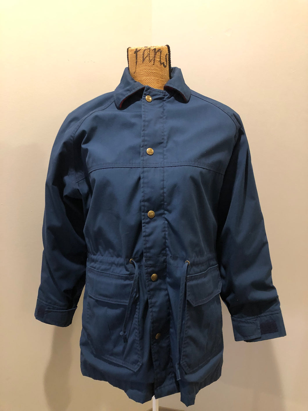 Kingspier Vintage - Woolrich Woman navy jacket with raglan sleeves, hood, zipper, snap closures with sheep logo, two flap pockets, drawstring at waist and red plaid wool lining. Made in the USA. Size medium. 