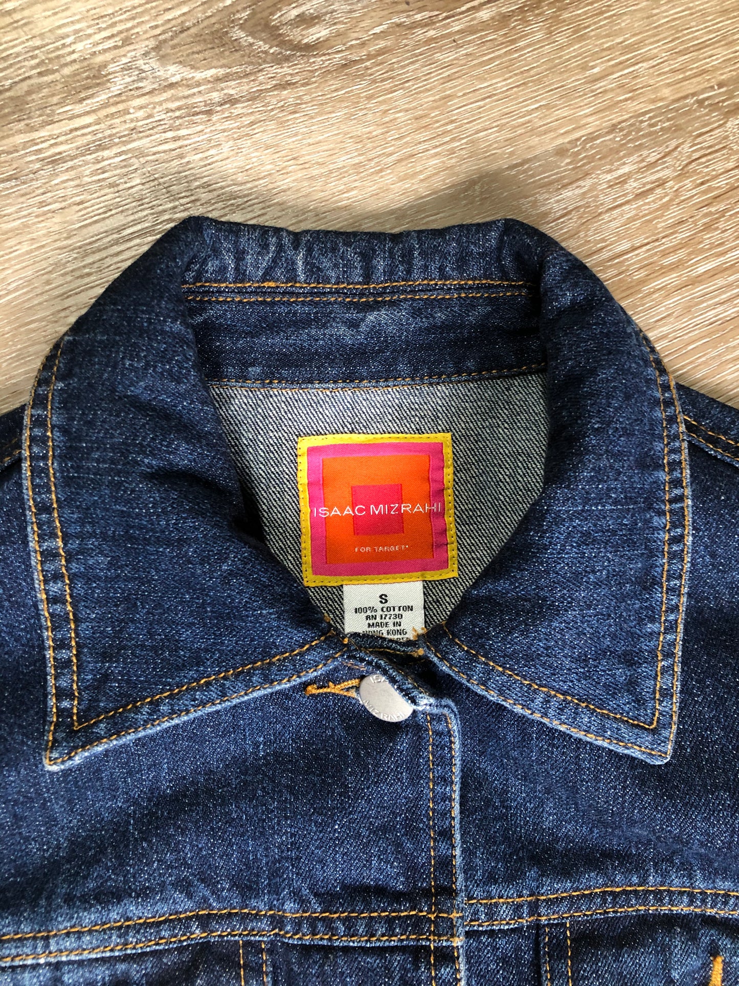 Kingspier Vintage - Isaac Mizrahi denim safari style jacket in a dark wash with belt in the back, button closures, four flap pockets and two hand warmer pockets. Size small.