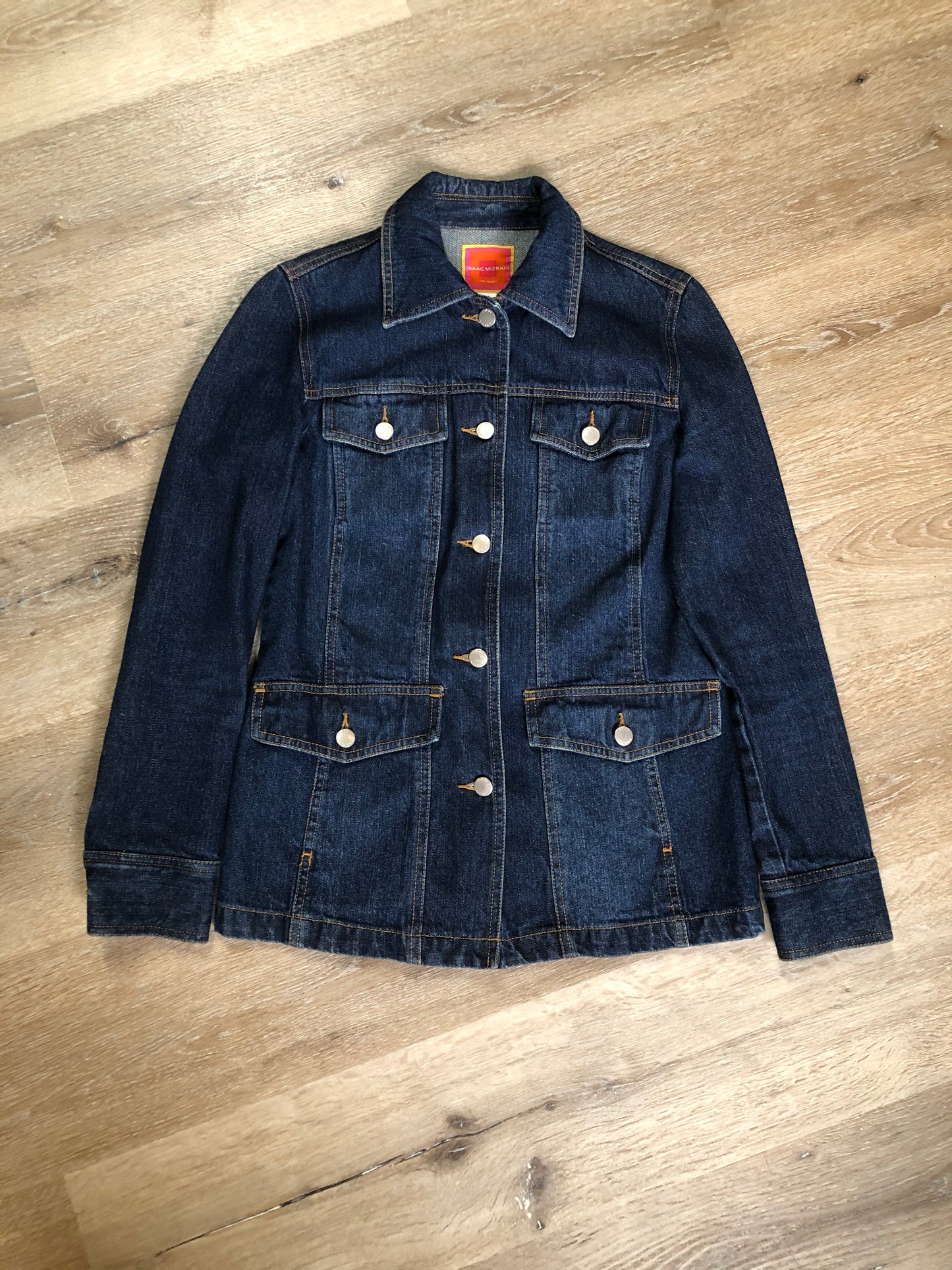 Kingspier Vintage - Isaac Mizrahi denim safari style jacket in a dark wash with belt in the back, button closures, four flap pockets and two hand warmer pockets. Size small.