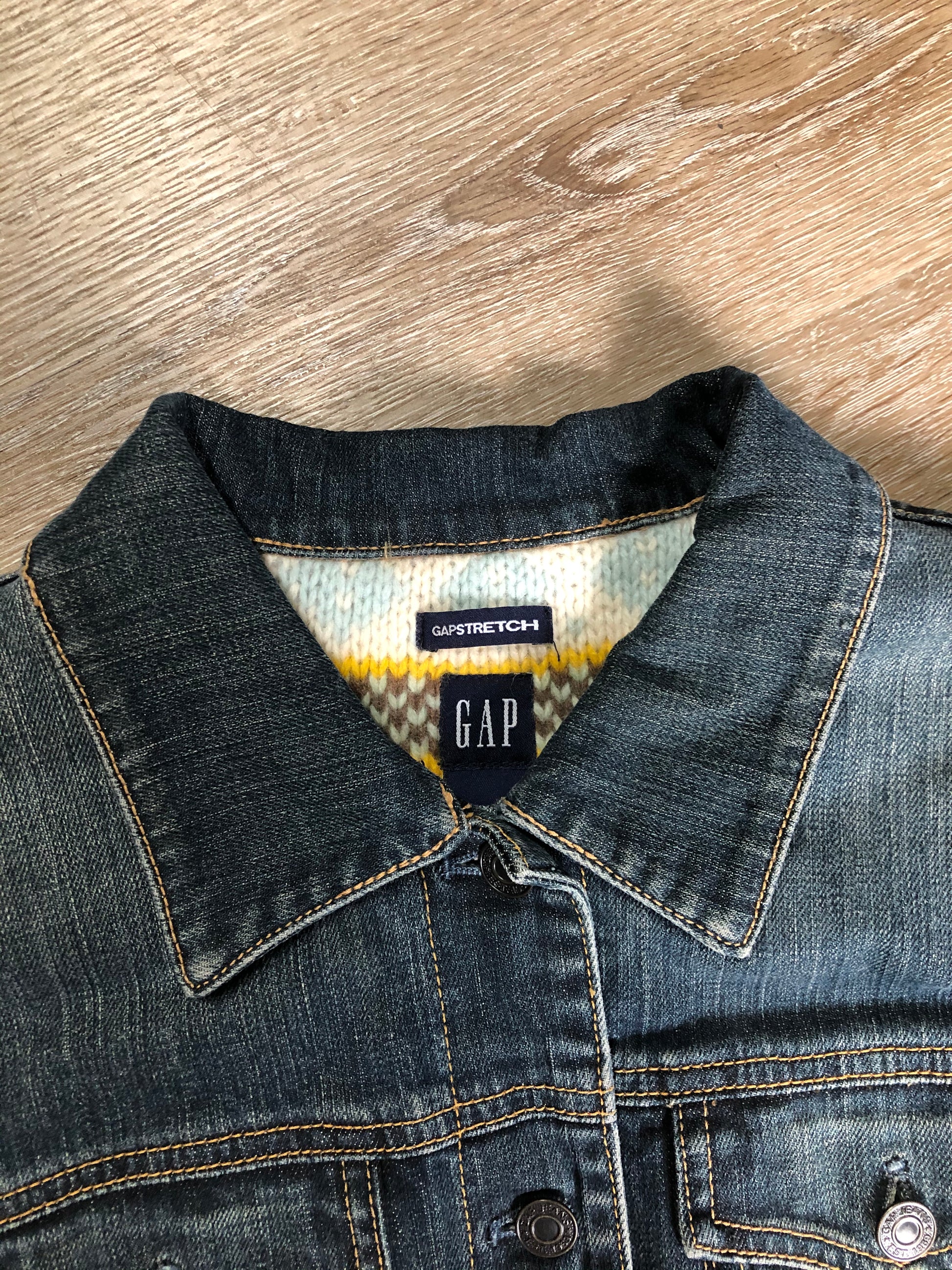 Kingspier Vintage - Gap denim jacket in a “dirty wash” with a colourful 100% lambswool lining, quilted lining in the arms, button closures and two flap pockets on the chest. Size large.