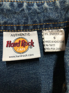 Kingspier Vintage - Hard Rock Cafe denim work shirt style jacket in a “dirty wash” with snap closures, flap pockets, “Hard Rock Cafe” is stitched above the pocket and "Chicago" is stitched on the cuff. Size small.