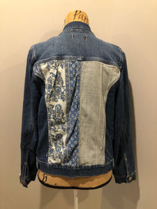 Kingspier Vintage - Nine West Vintage Collection denim jacket in a medium wash with vintage look material piece in the back, button clusters, two vertical pockets and two flap pockets on the chest. Size large.