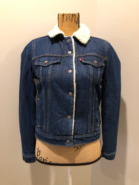 Kingspier Vintage - Levi’s denim sherpa trucker jacket in a medium wash with faux fur lining, snap closures, vertical pockets and two flap pockets. Size small.