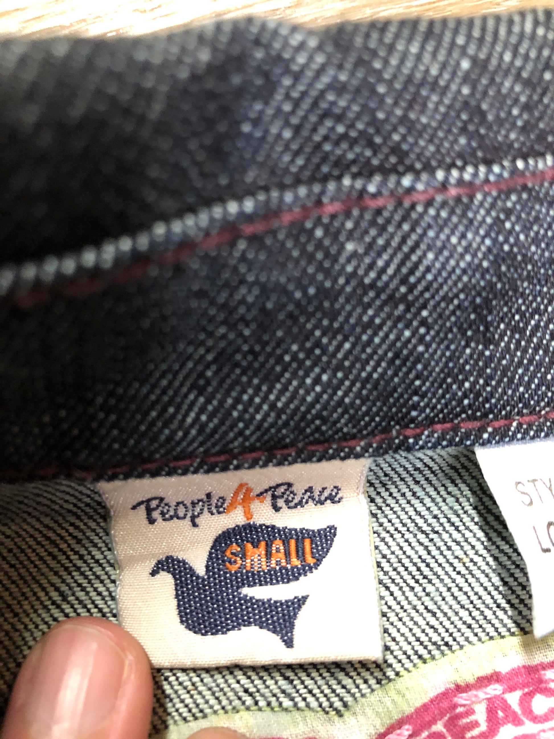 Kingspier Vintage - People for Peace cropped denim jacket in a dark wash with colourful embroidery all over, button closures, two zip pockets and two flap pockets on the chest. Size small.