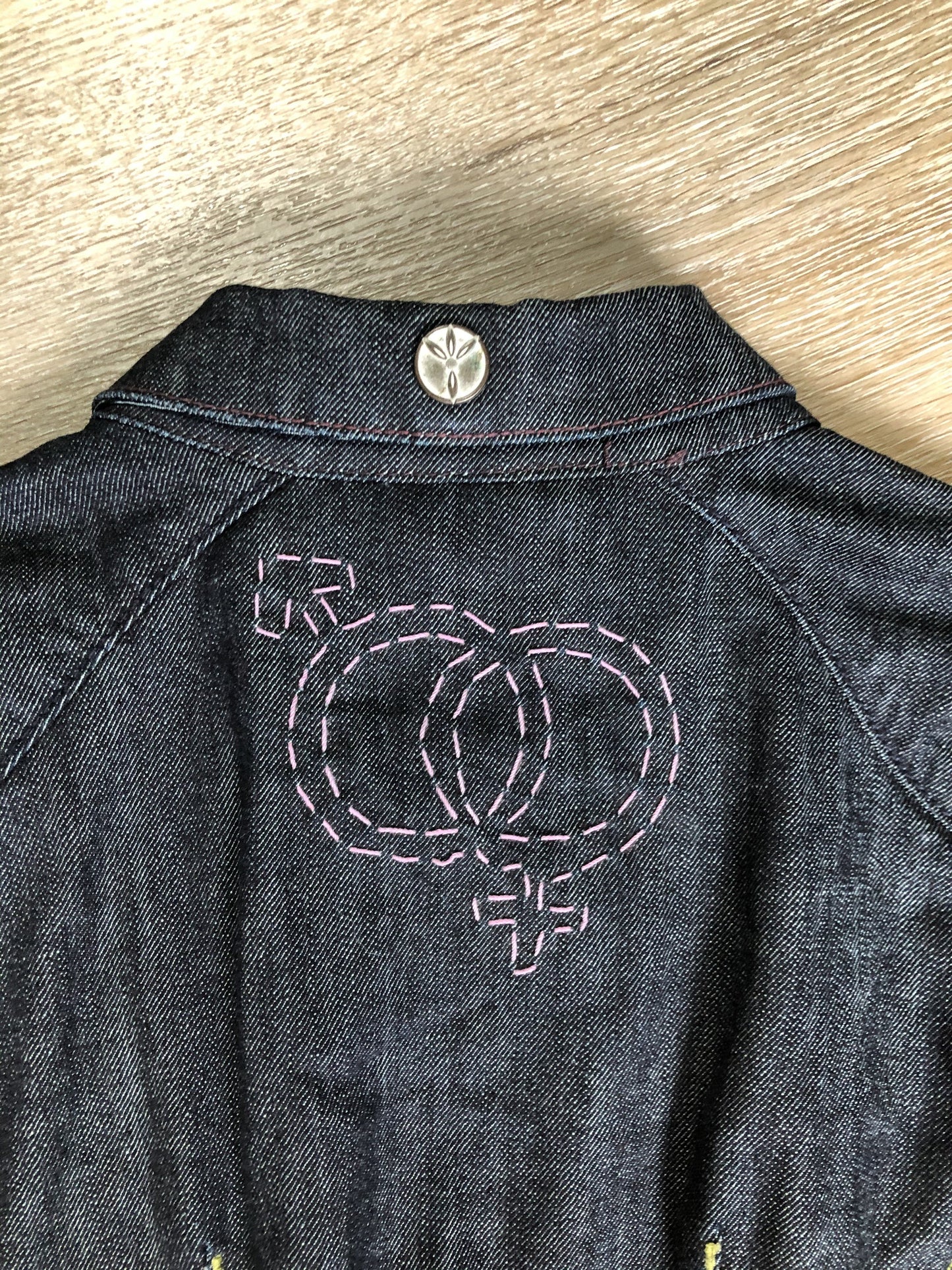 Kingspier Vintage - People for Peace cropped denim jacket in a dark wash with colourful embroidery all over, button closures, two zip pockets and two flap pockets on the chest. Size small.