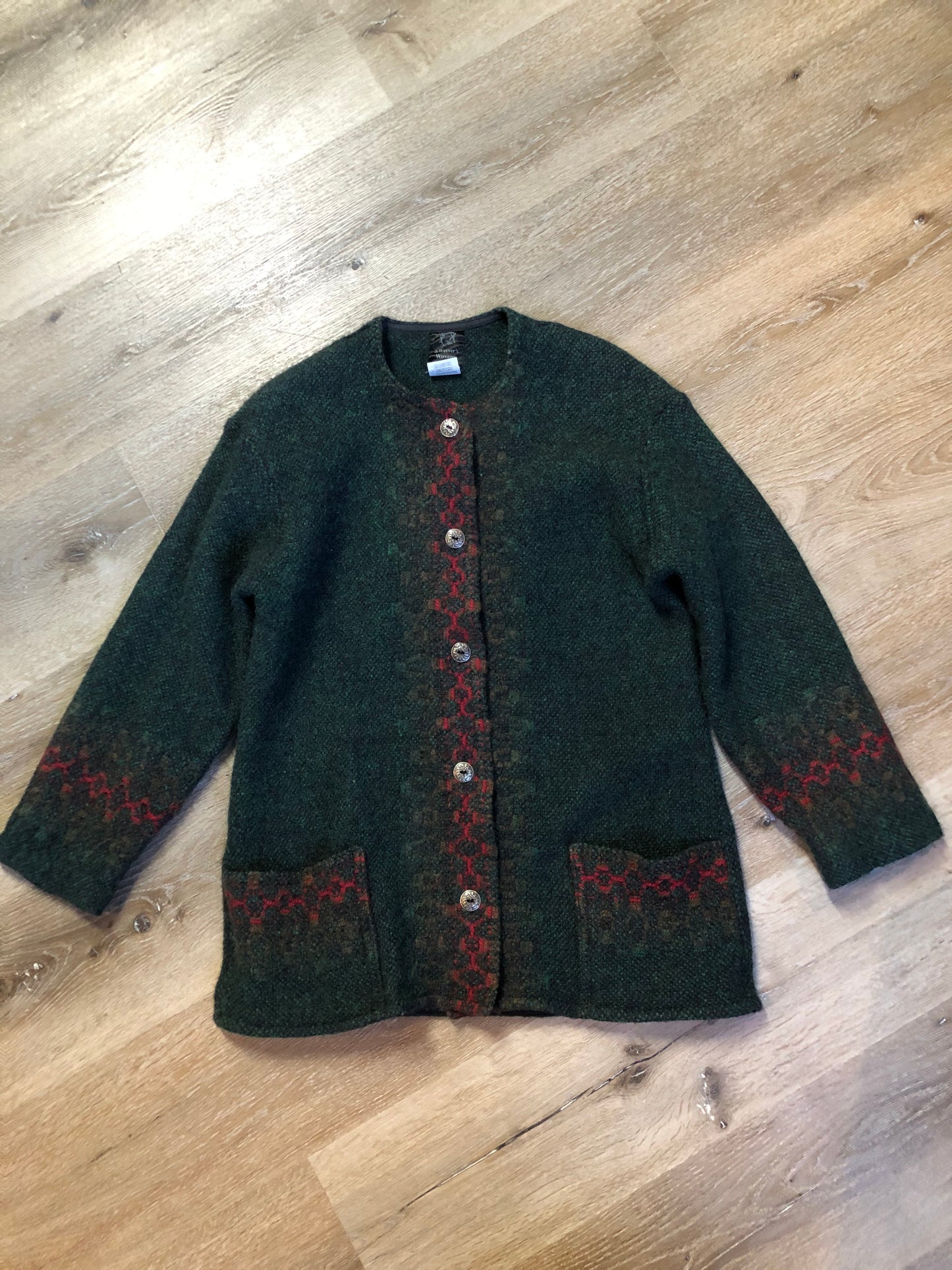 Kingspier Vintage - Deweevers wovens 100% wool cardigan in deep green with red design woven in, patch pockets and silver buttons with floral design. Made in Aylesford, NS. Size medium.