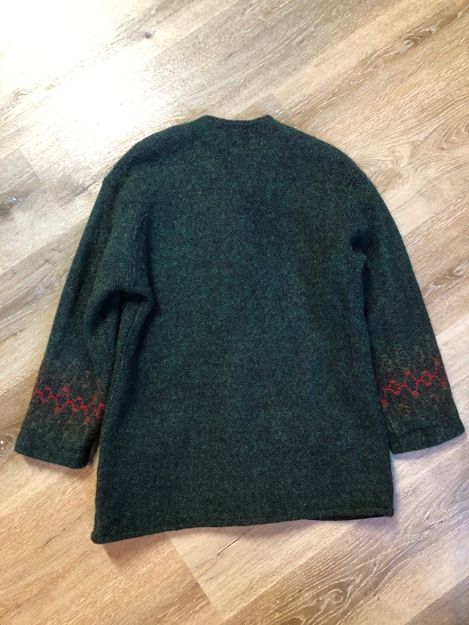 Kingspier Vintage - Deweevers wovens 100% wool cardigan in deep green with red design woven in, patch pockets and silver buttons with floral design. Made in Aylesford, NS. Size medium.