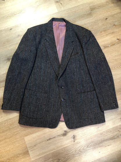 Kingspier Vintage - Harris Tweed grey herringbone with subtle red and blue stripe 100% wool jacket. This jacket is a two button, notch lapel with two patch pockets, a breast pocket and three inside pockets.