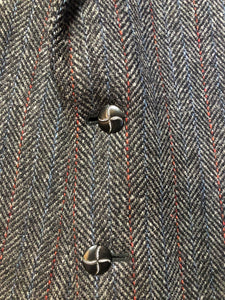 Kingspier Vintage - Harris Tweed grey herringbone with subtle red and blue stripe 100% wool jacket. This jacket is a two button, notch lapel with two patch pockets, a breast pocket and three inside pockets.