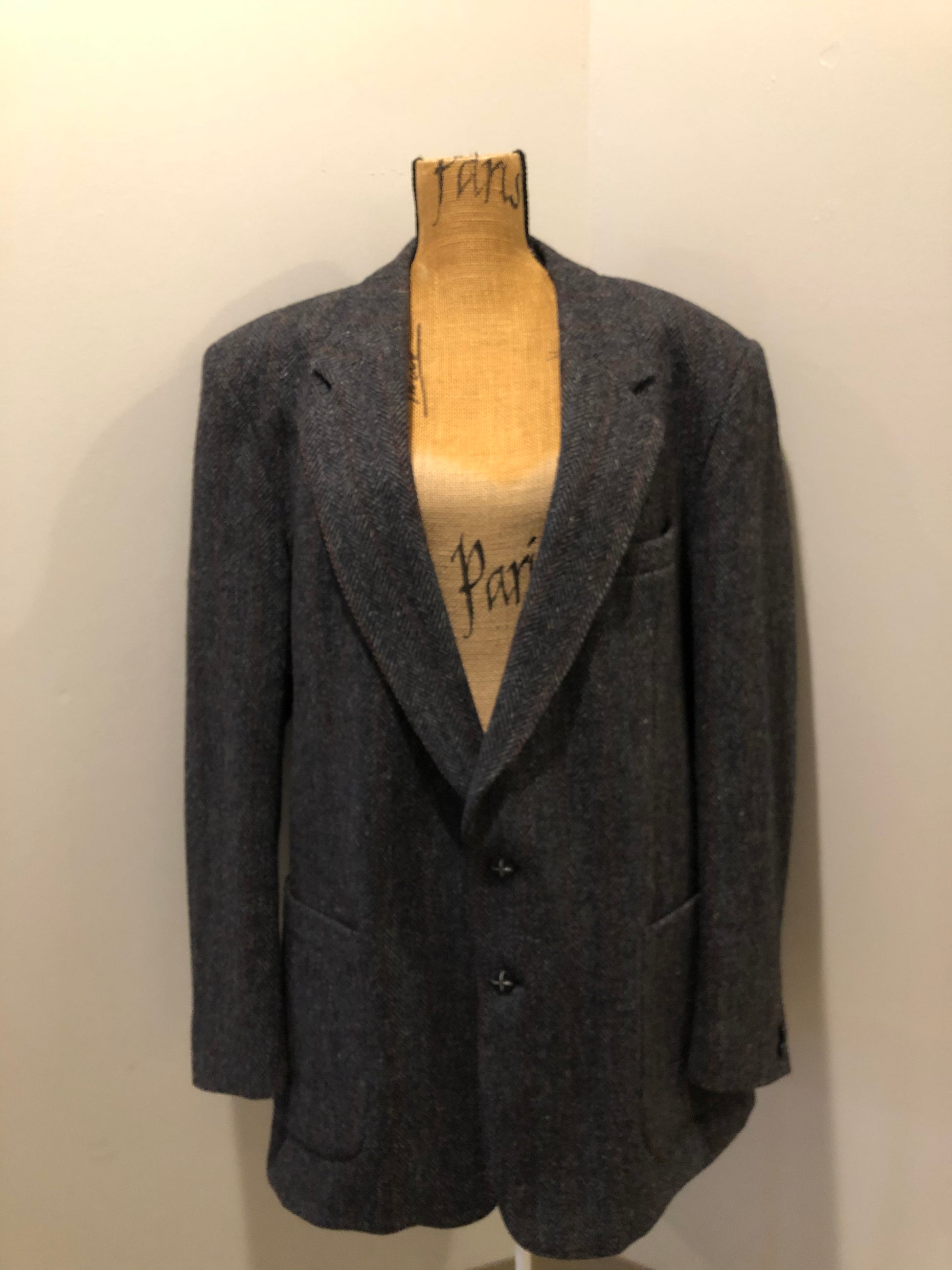 Kingspier Vintage - Harris Tweed grey herringbone with subtle red and blue stripe 100% wool jacket. This jacket is a two button, notch lapel with two patch pockets, a breast pocket and three inside pockets.