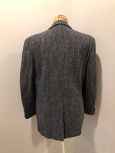 Load image into Gallery viewer, Kingspier Vintage - Harris Tweed black and white 100% wool tweed jacket. This jacket is a two button, notch lapel with two flap pockets, a breast pocket and two inside pockets. Made in Canada. Size 40.
