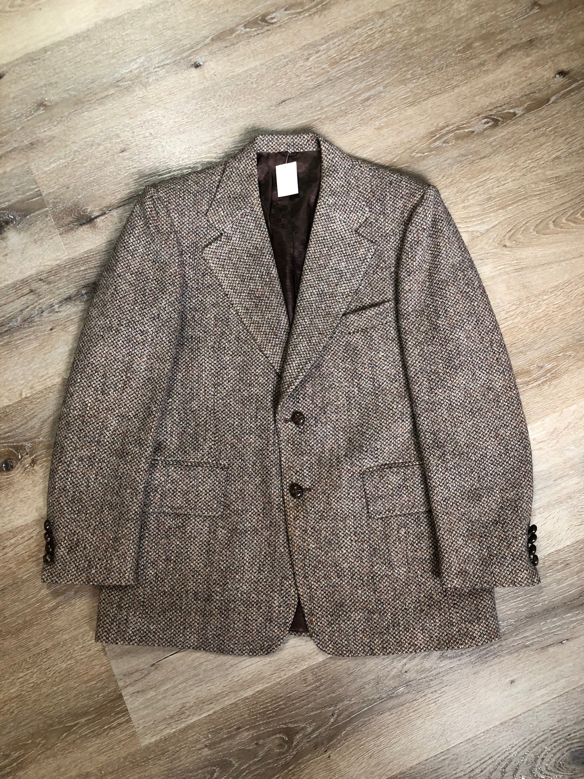 Kingspier Vintage - Harris Tweed beige with rust and grey flecks 100% wool tweed jacket. This jacket is a two button, notch lapel with two flap pockets, a breast pocket and two inside pockets. Made in Canada. Size 42R.