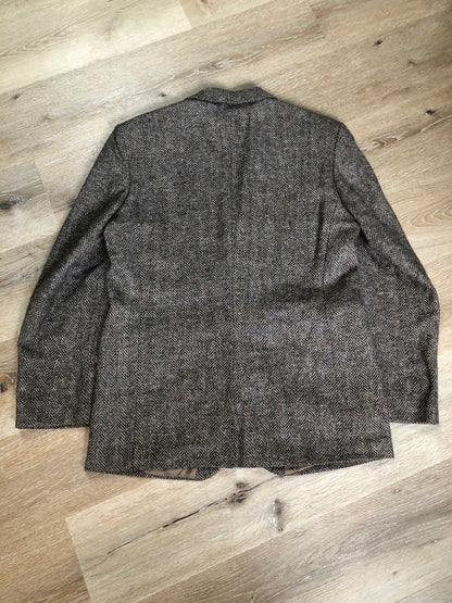 Kingspier Vintage - Paul Henry grey herringbone with flecks blue and rust 100% wool tweed jacket. This jacket is a two button, notch lapel with two flap pockets, a breast pocket and three inside pockets. Made in Europe.