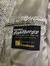 Load image into Gallery viewer, Kingspier Vintage - Morris Goldberg’s grey herringbone 100% wool tweed jacket. This jacket is a two button, notch lapel with two flap pockets, a breast pocket and three inside pockets. Made in Halifax, Nova Scotia.
