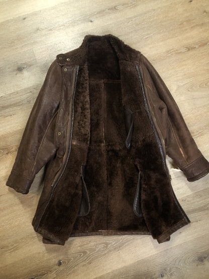 Kingspier Vintage - Jean Claude Poitras medium brown shearling coat. This coat features a speckled texture, shearling lining, zipper and snap closures, one zip pocket on the chest and two welt pockets. Size medium.