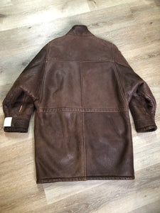 Kingspier Vintage - Jean Claude Poitras medium brown shearling coat. This coat features a speckled texture, shearling lining, zipper and snap closures, one zip pocket on the chest and two welt pockets. Size medium.