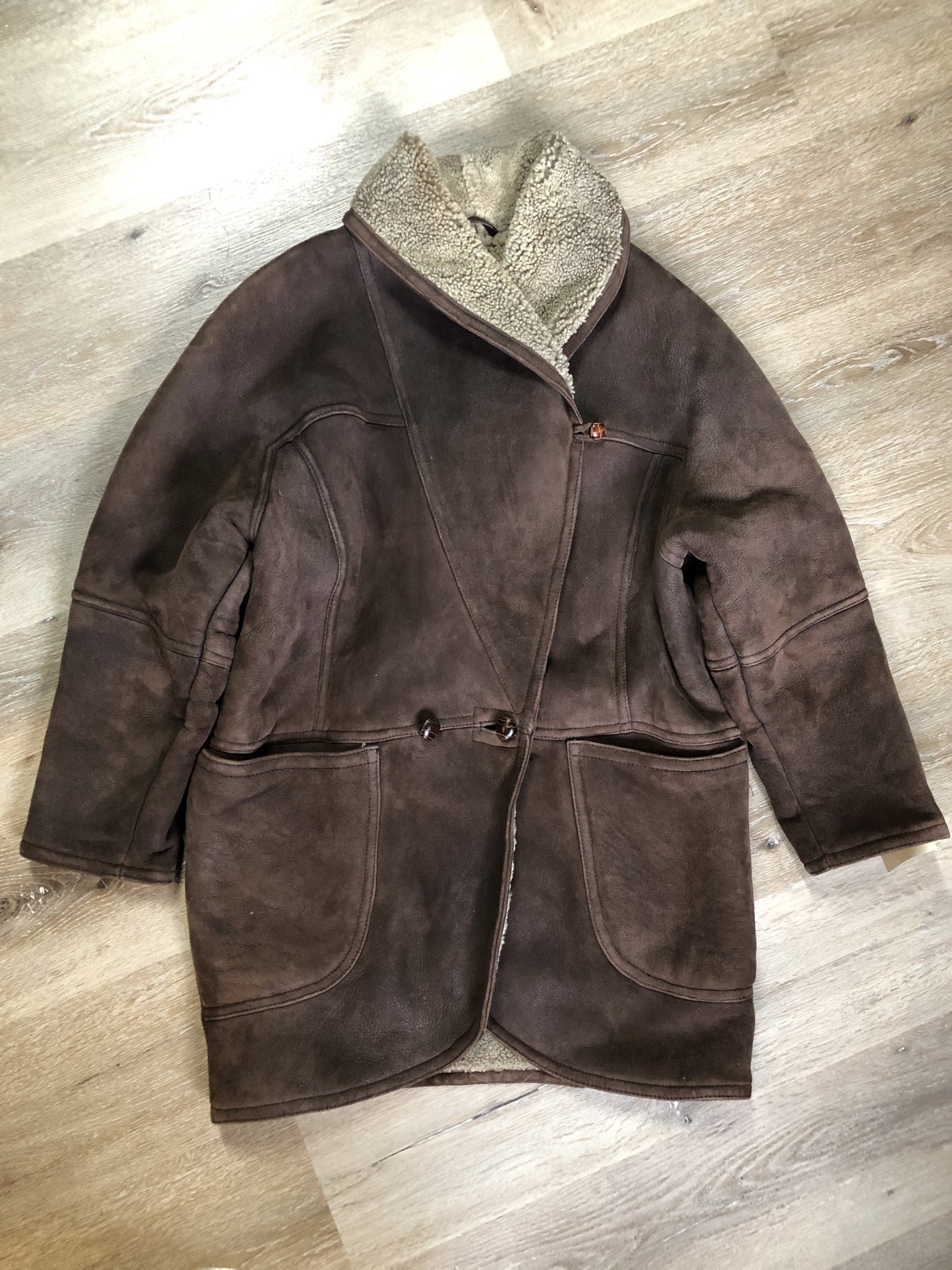 Kingspier Vintage - Positano Pelle dark brown shearling coat. This coat features shearling trim and lining, shall collar, wooden button closures and patch pockets. Made in Turkey. Size small.