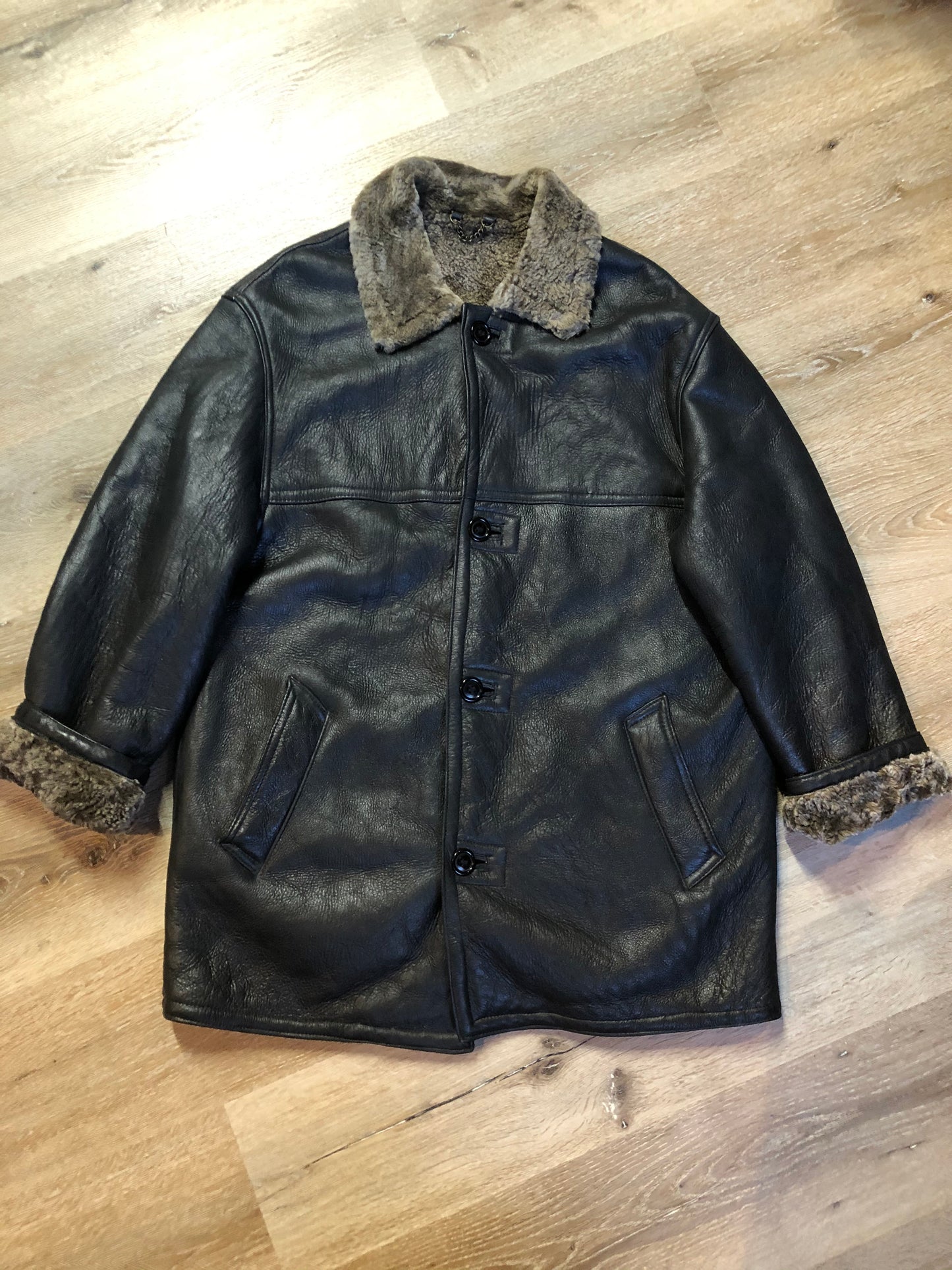 Kingspier Vintage - 2dm black sheepskin coat with shearling trim and lining, button closures and slash pockets.