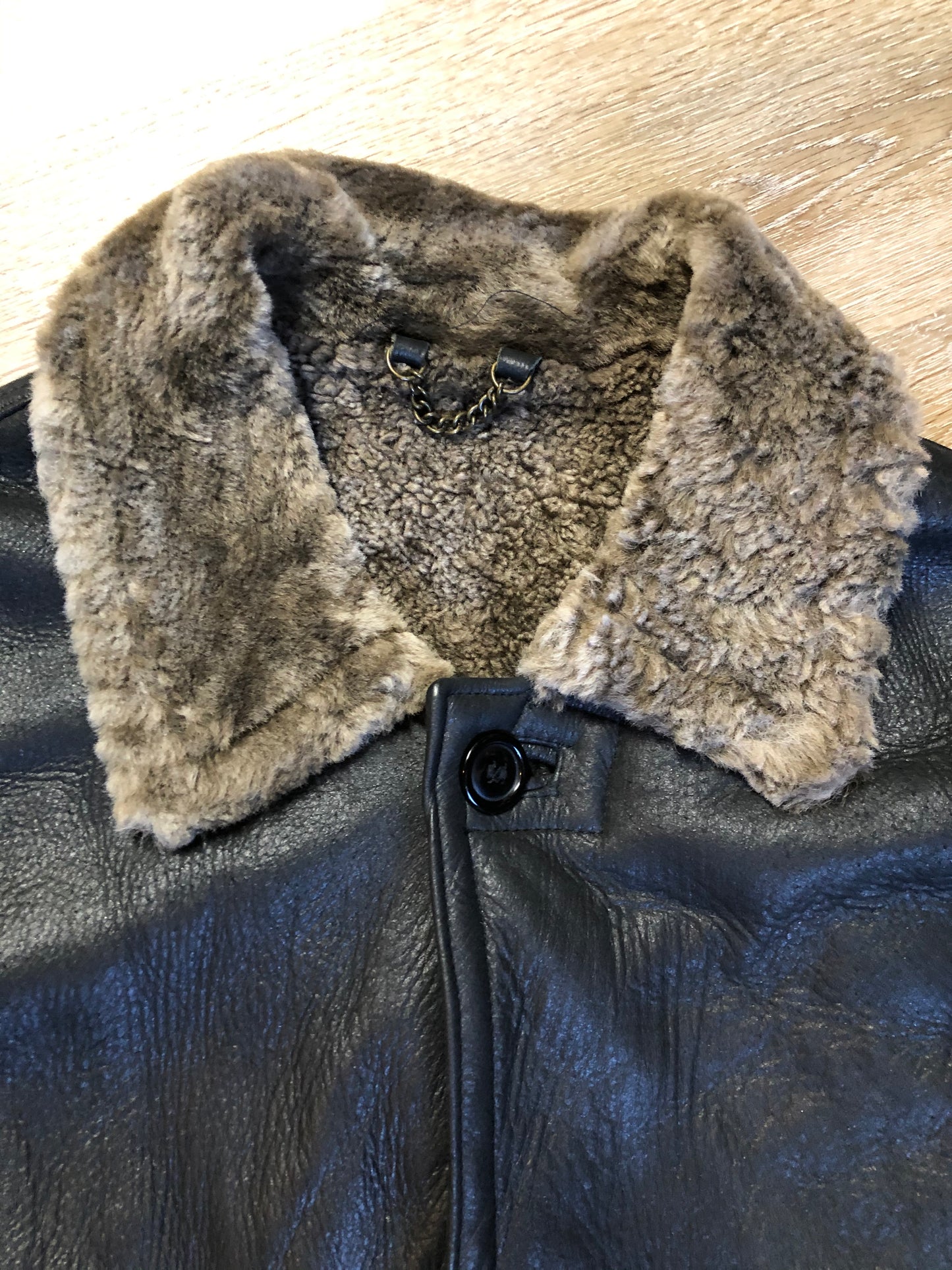 Kingspier Vintage - 2dm black sheepskin coat with shearling trim and lining, button closures and slash pockets.