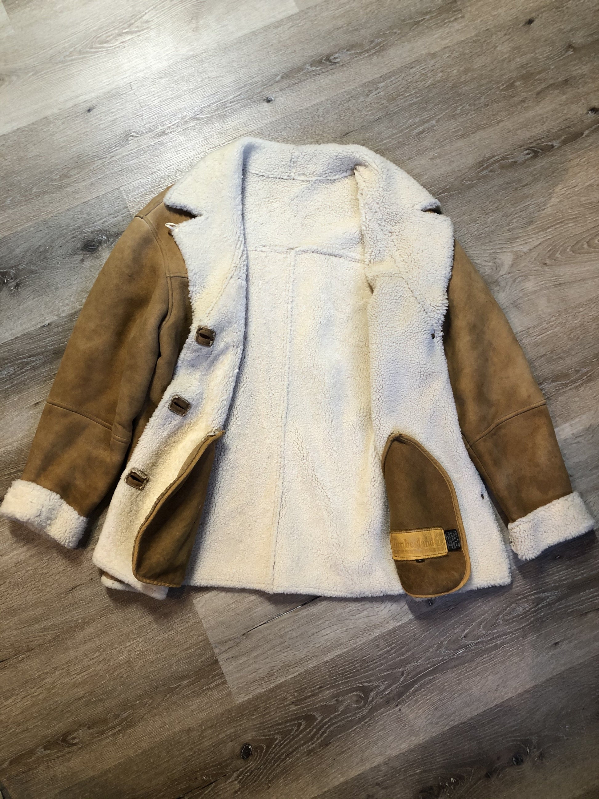 Kingspier Vintage - Timberland tan suede lambskin coat with shearling trim and lining, button closures and slash pockets. Coat is water resistant. Size medium.