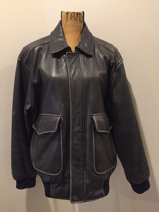 Kingspier Vintage - Black leather pilot jacket with zipper and snap closures, flap pockets, knit trim, inside pocket and plane pattern on inside lining. Size large. 