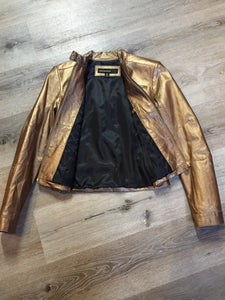 Kingspier Vintage - Rocawear metallic gold leather moto jacket with “RW” detail zippers, chain lace-up detail on sides and “ROCAWEAR” written in chain across the back. There is a front zipper, two horizontal zip pockets on the chest, two snap closures on the stand up collar and a pocket on the inside. Size small.