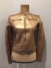 Load image into Gallery viewer, Kingspier Vintage - Rocawear metallic gold leather moto jacket with “RW” detail zippers, chain lace-up detail on sides and “ROCAWEAR” written in chain across the back. There is a front zipper, two horizontal zip pockets on the chest, two snap closures on the stand up collar and a pocket on the inside. Size small.
