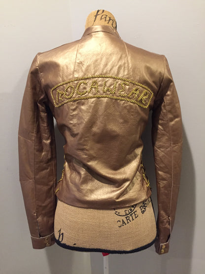 Kingspier Vintage - Rocawear metallic gold leather moto jacket with “RW” detail zippers, chain lace-up detail on sides and “ROCAWEAR” written in chain across the back. There is a front zipper, two horizontal zip pockets on the chest, two snap closures on the stand up collar and a pocket on the inside. Size small.