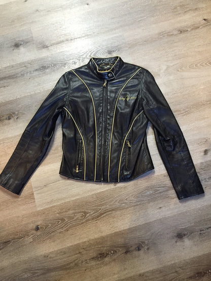 Kingspier Vintage - Baby Phat black leather moto jacket with gold piping and “Baby Phat” embroidered on the chest, front zipper and two vertical zip pockets. A pattern is stitched into the elbows and “Baby Phat” is stitched across the back. Size small.