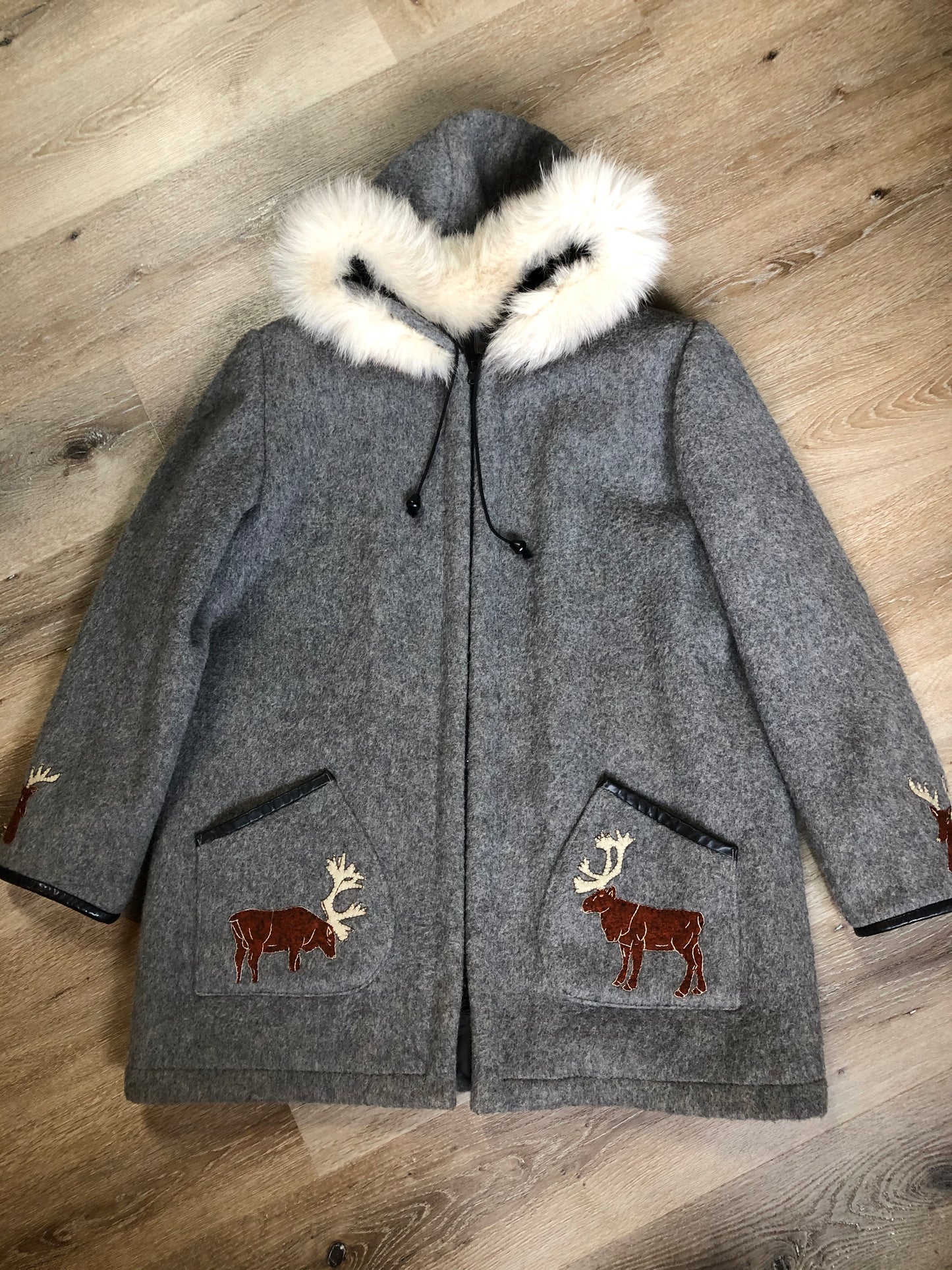 Kingspier Vintage - James Bay pure virgin wool northern parka in grey. This parka features a hood with white fur trim, zipper closure, quilted lining, knit inside hidden cuffs, patch pockets, felt deer appliqués on the front and on the sleeves. Made in Canada.