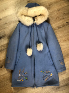 Kingspier Vintage - Northern Sun pure virgin wool northern style parka in light blue. This parka features a hood with white fur trim, zipper closure, quilted lining, slash pockets, hidden inside knit cuffs, embroidered geese design on the front and back and boats embroidered on the sleeves. Made in Canada.
