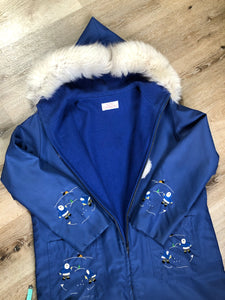 Kingspier Vintage - Blue northern parka made by Marilyn Bessey with wool blend lining, hood with white fur trim, fur Pom poms, zipper closure, patch pockets, arctic life design embroidered on the front pockets and the sleeves. Made in Canada. 